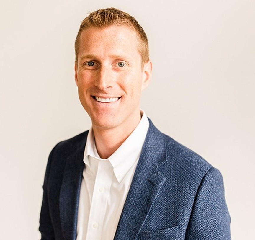 Picture of Craig Toberman, CFA, CPA, CFP® and partner at Toberman Becker Wealth. Craig is wearing a collared white button-up shirt under a dark blue blazer and is smiling at the camera.
